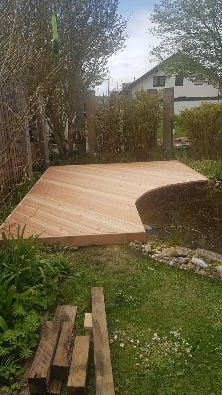 Terrasse mit geschwungener Vorderkante entlang eines Gartenteichs